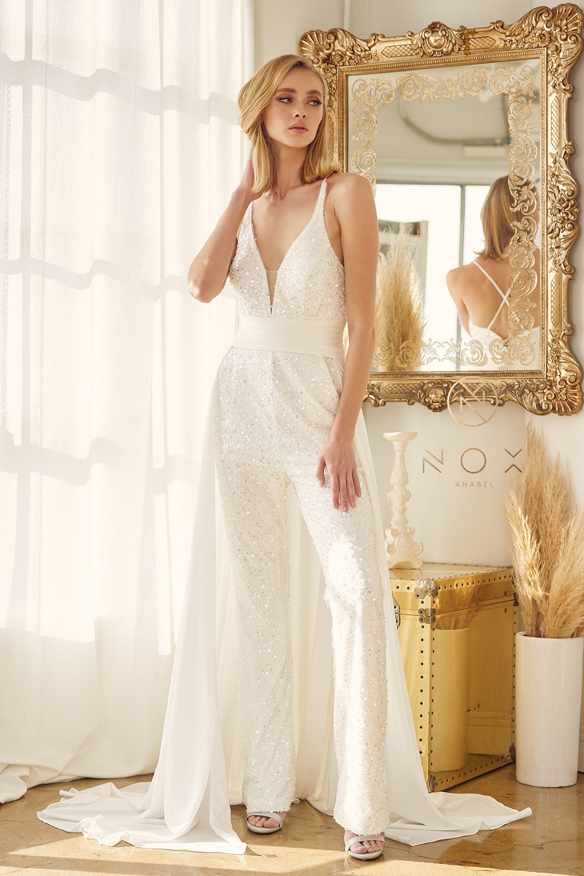 Nox Anabel JE926 Sequin & Pearl Embellished Bridal V Neck Jumpsuit with detachable  Overskirt. Pockets in the pant legs. This Wedding Pant suit has a PLUNGING NECKLINE WITH BEADING DETAILS IN JUMPSUIT WITH A CAPE FROM WAIST. Great for receptions!  Available Sizes: 2-16  Available Colors: White