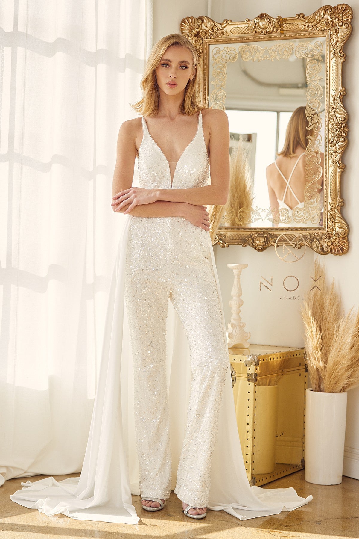 Nox Anabel JE926 Sequin & Pearl Embellished Bridal V Neck Jumpsuit with detachable  Overskirt. Pockets in the pant legs. This Wedding Pant suit has a PLUNGING NECKLINE WITH BEADING DETAILS IN JUMPSUIT WITH A CAPE FROM WAIST. Great for receptions!  Available Sizes: 2-16  Available Colors: White