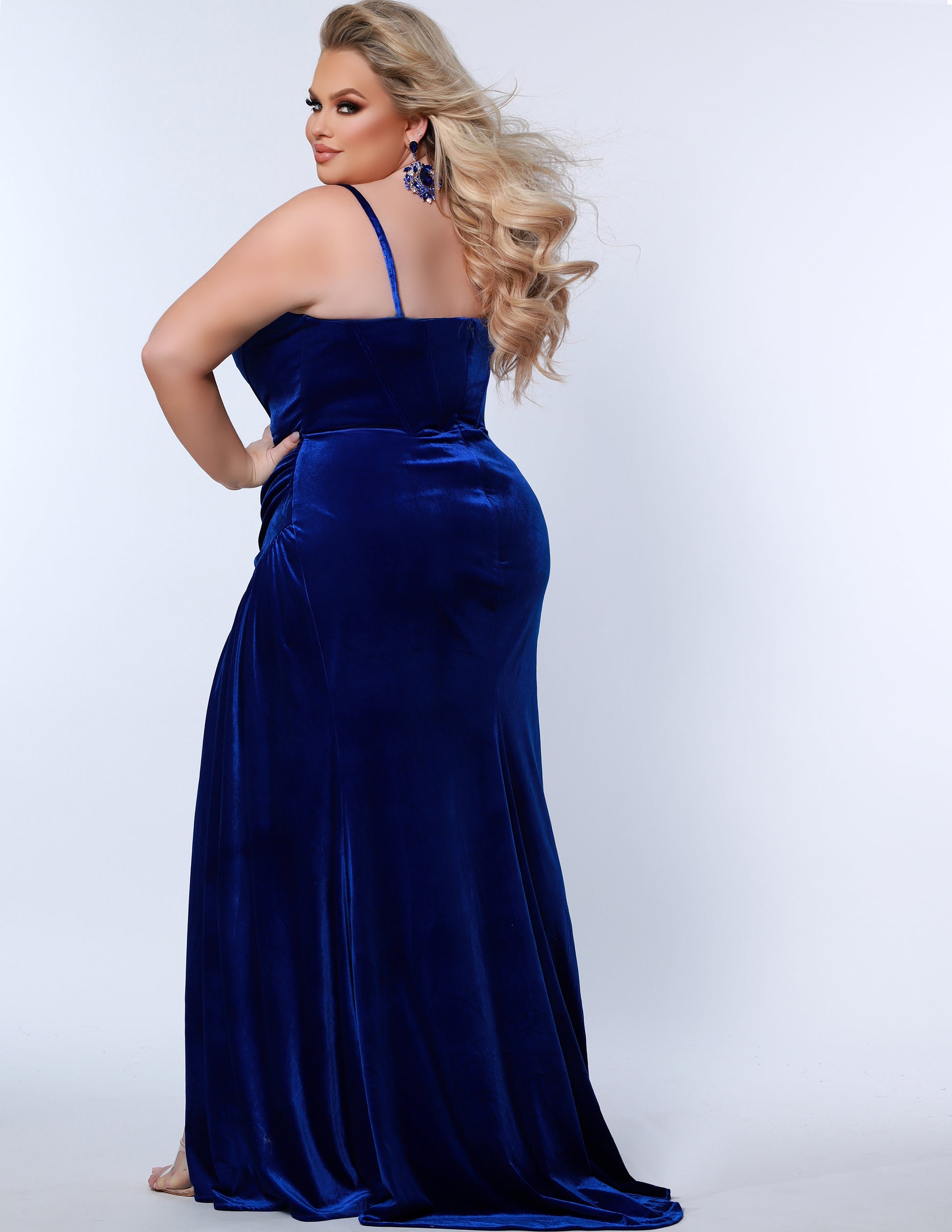 The Sydney's Closet SC7342 is a luxurious Velvet Prom Dress Strapless Evening Gown with a fitted and ruched silhouette, ideal for special occasions. It offers a classic and timeless look with a touch of sophistication. Its rich fabric provides a comfortable fit and feel.