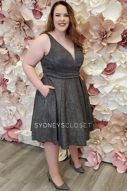 Sydney's Closet SC8108 is a short a line metallic knit shimmer formal homecoming party cocktail dress. Stretchy material adds a comfortable wear all night long. V Neckline with mesh insert and bra friendly straps. Fitted asymmetrical ruched waist. Knee length.