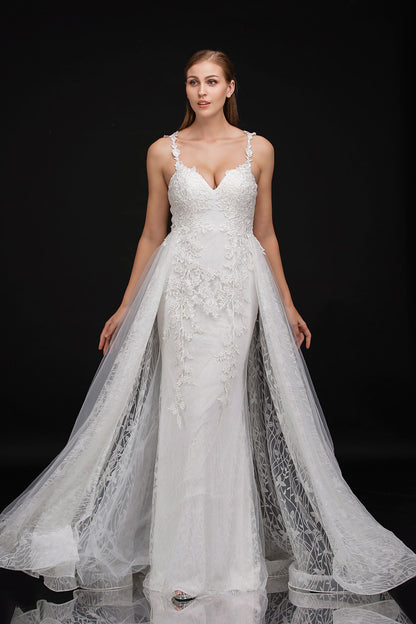 Nina Cancci 3159 is a long Lace Fitted Ivory Floral Lace Applique strap wedding dress. cracked Ice Over skirt and sweeping train. Stunning Destination Bridal Gown. Great for Plus Size! Glitter sweetheart neckline. Accented scroll pattern on the flowing overskirt. shimmering bridal gown or unique wedding dress. Sheer lace embellished straps.   Available Sizes: 8  Available Colors: Ivory/Nude