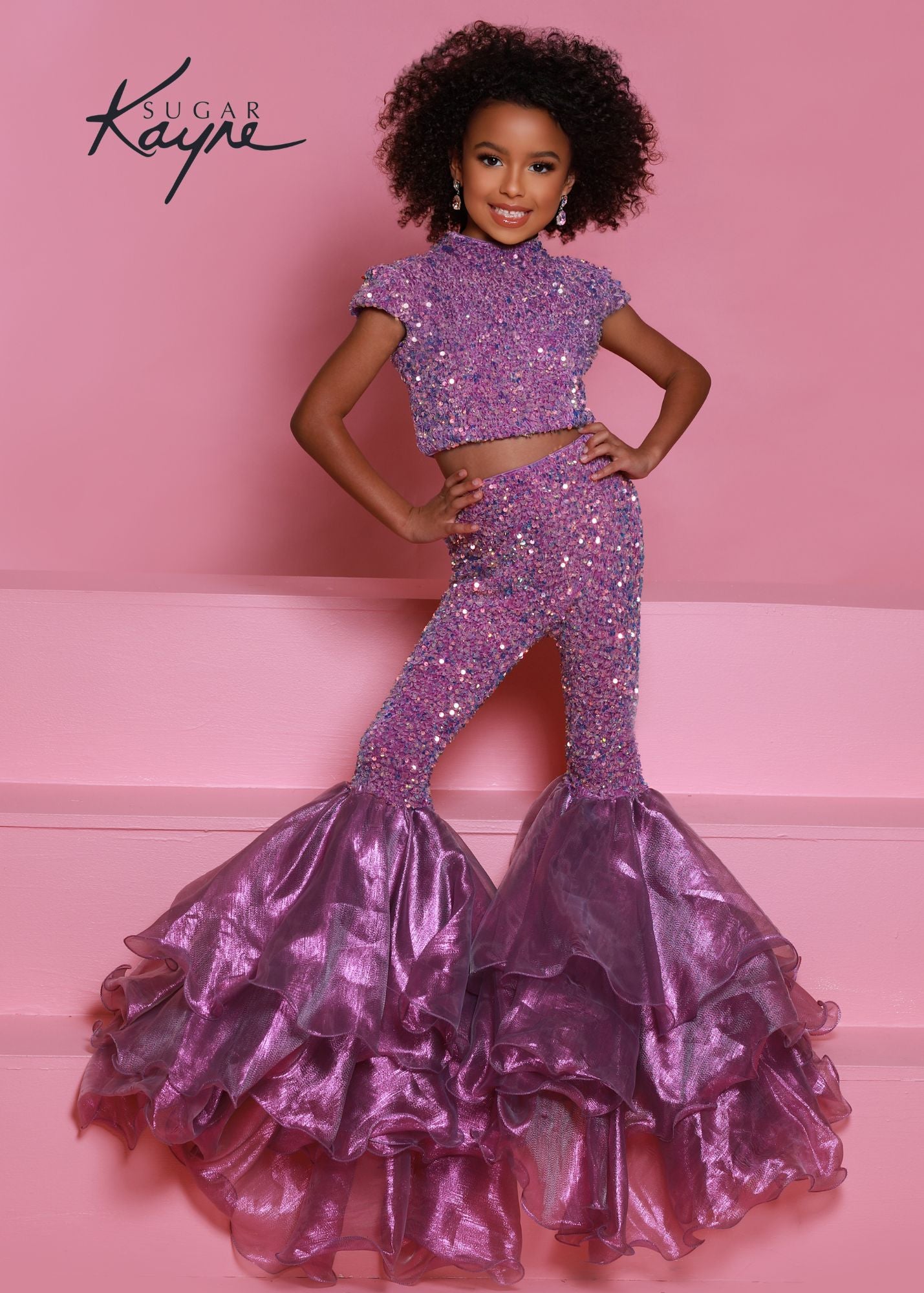 Sugar Kayne C164 This is a two piece girls fun fashion jumpsuit. Featuring Sequin stretch velvet fabric not only is it comfortable but glamorous on stage! high neckline with short sleeves, Backless with an organza bow to tie. Lush Bell Bottoms. Unicorn color features iridescent shimmer organza while royal and red feature regular organza orchid purple back