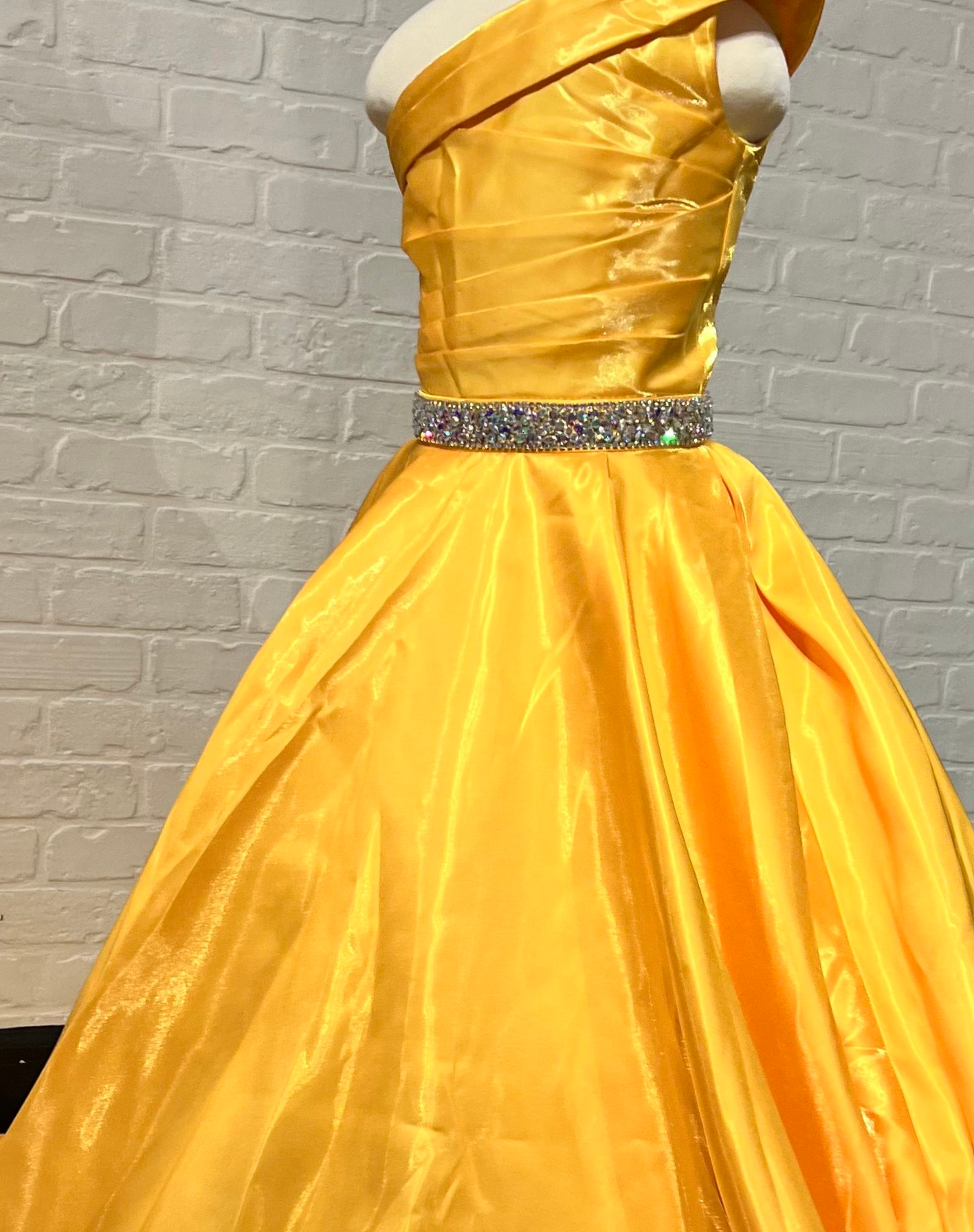 Sugar Kayne C312 Girls and Preteens Long A Line One Shoulder Formal Pageant Dress Gathered Bodice Make a bold impression at your next pageant. This one-shoulder shimmer satin ball gown has a hand-beaded waistband to highlight the waist.  Colors: Cherry, White, Marigold