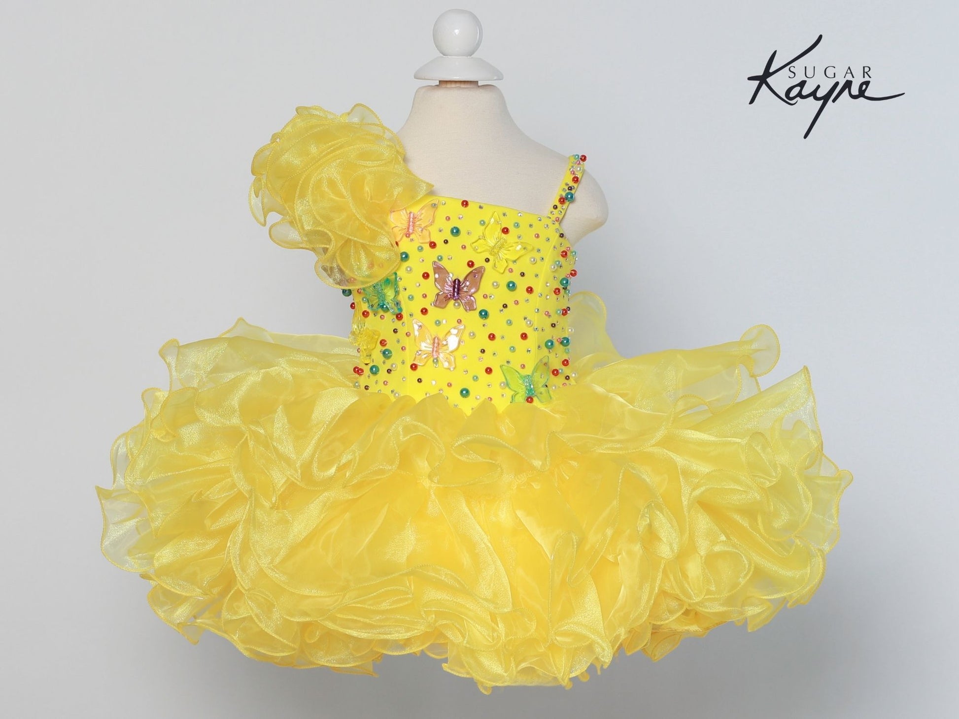 Sugar Kayne C209 Short Cupcake Ruffle One Shoulder Girls Pageant Dress Butterflies Great for any age! Corset Back  Sizes: 0M, 6M, 12M, 18M, 24M, 2T, 3T, 4T, 5T, 6T  Colors: White/Multi, Yellow/Multi, Aqua/Multi