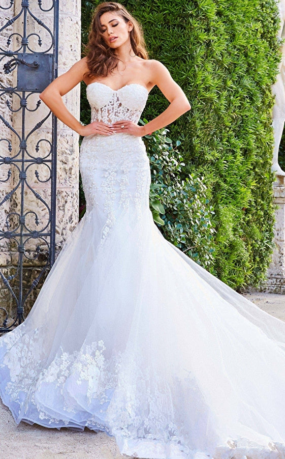 Jovani Bridal JB07260 Sheer Corset Lace Mermaid Wedding Dress Bridal Gown Train Strapless  This Jovani JB07260 off white wedding dress is styled in soft tulle with floral appliques, featuring a sheer corset bodice with a strapless sweetheart neckline. Lush godets form this trumpet-style bridal gown, finished with a lace border hemline and a semi-cathedral train.  Available Sizes: 00-24  Available Colors: Off White
