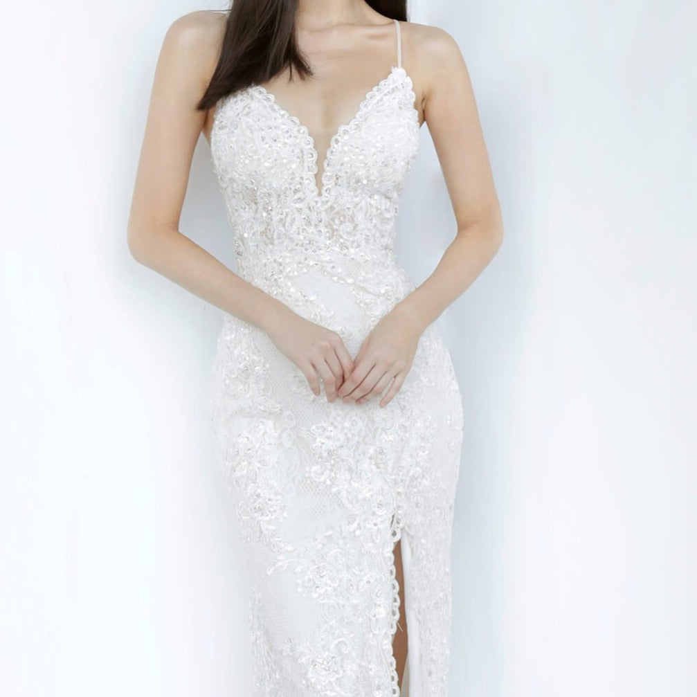 Jovani JVN00864 is an absolute stunner! Long Fitted Prom Dress or Unique Sexy Wedding Dress. Delicately Embellished Lace with a Plunging neckline & High Slit with scallop lace edges. Spaghetti straps with a slightly sheer lace bodice. JVN 00864