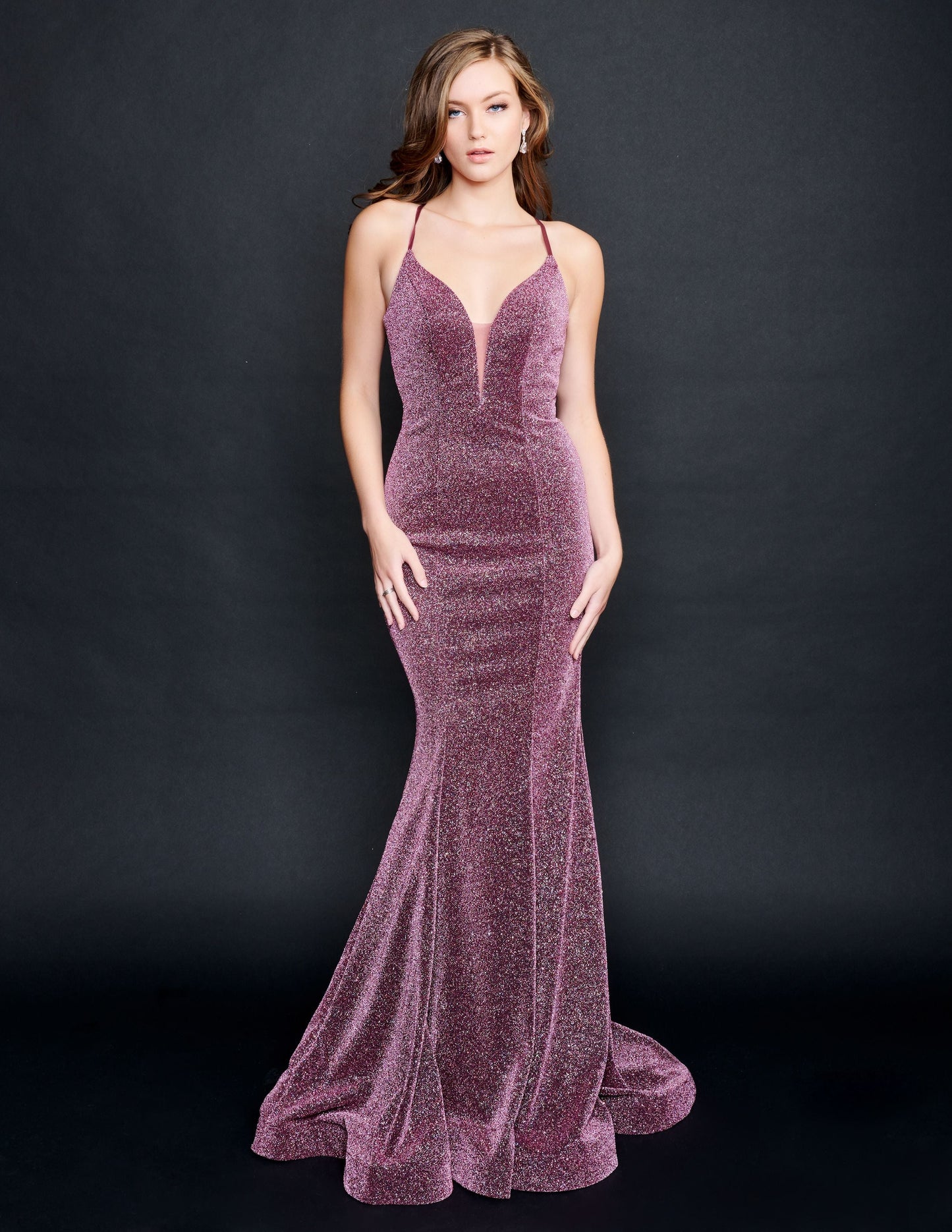Nina Canacci 9136  This is a long fitted mermaid prom dress with a plunging v neckline.  Thin spaghetti straps lace up and tie in the back.  The skirt has horsehair trim. Pageant Gown