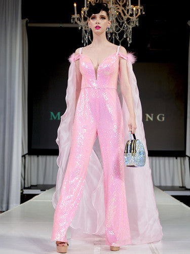 Marc Defang 8099 This is a long pageant formal wear jumpsuit that is made of sequins and has off the shoulder straps.  The straps are attached to a cape with feathers at the shoulders.  Wow the crowd at your next pageant. hot pink