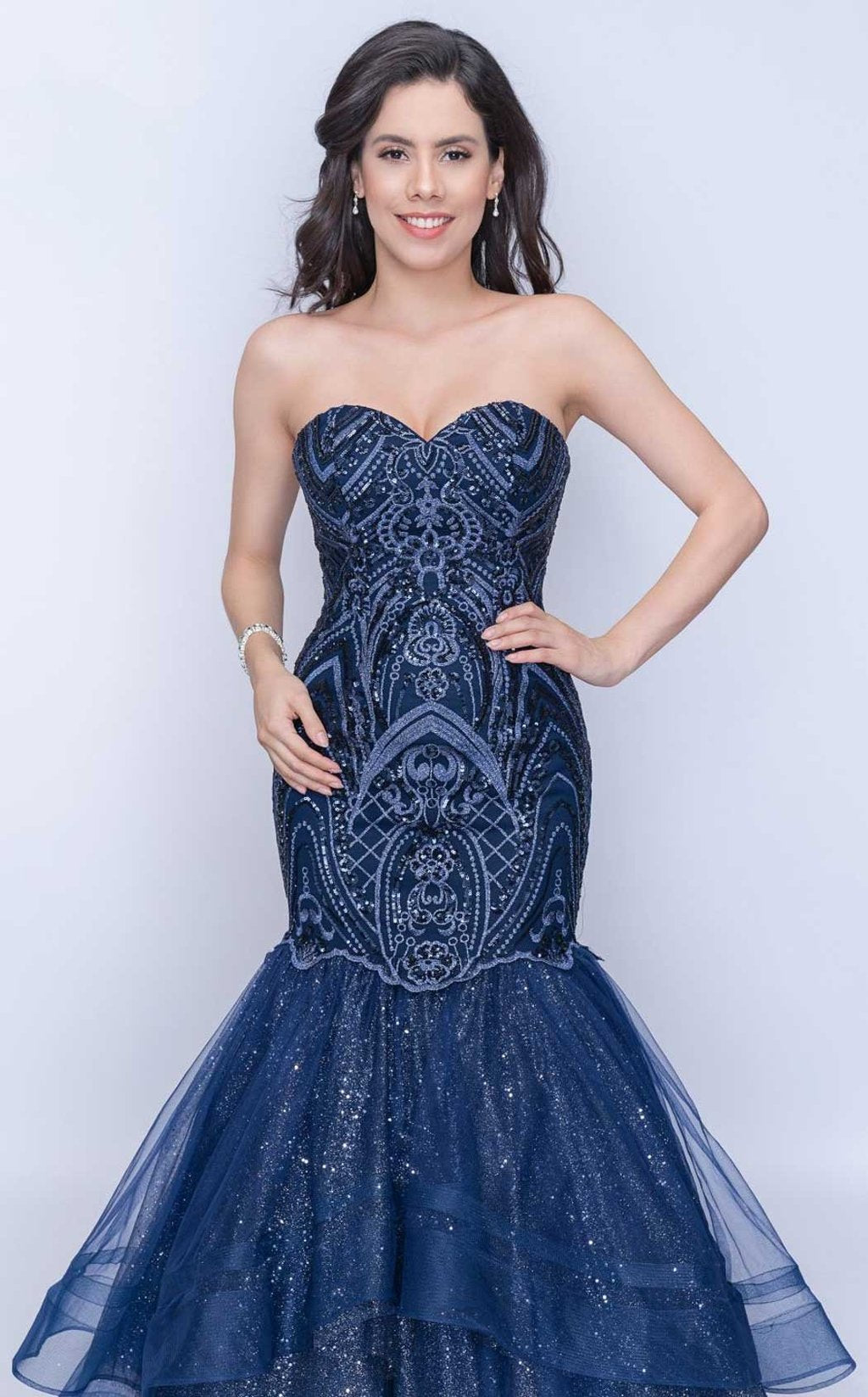 Nina Canacci 1407 is a long fitted mermaid prom dress. strapless sweetheart neckline with a fitted embroidered lace embellished bodice. trumpet flared mermaid skirt features layers of glitter tulle ruffled with double horse hair traim.  Available Size: 4  Available Color: Navy