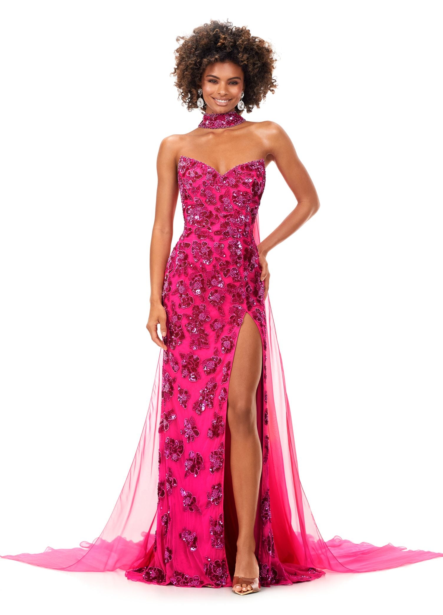 Ashley Lauren 11351 All we can say is WOW! This strapless beaded gown with crystal detailing is sure to make a statement at your next event. The gown features a gorgeous beaded neck choker with attached chiffon cape. Strapless Gown Beaded Choker Chiffon Cape Left Leg Slit COLORS: Royal, Ivory, Red, Neon Pink