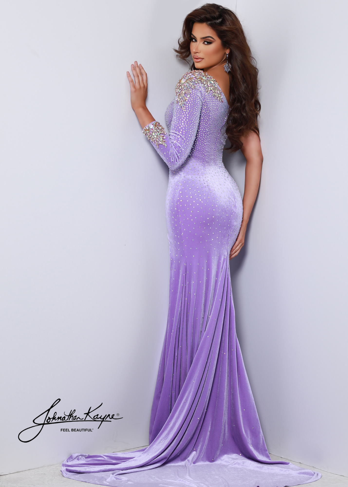 The Johnathan Kayne 2610 is a luxurious one-shoulder evening gown crafted from high-quality stretch velvet and embellished with hand-beaded rhinestones. The dress features a thigh-high slit and long sleeves for a chic, stylish look. Available in a variety of stunning hues, this breathtaking dress is sure to make you the star of any special occasion.  Colors: Flamingo, Neon Orange, Teal, Violet  Sizes: 00, 0, 2, 4, 6, 8, 10, 12, 14, 16, 18, 20, 22, 24
