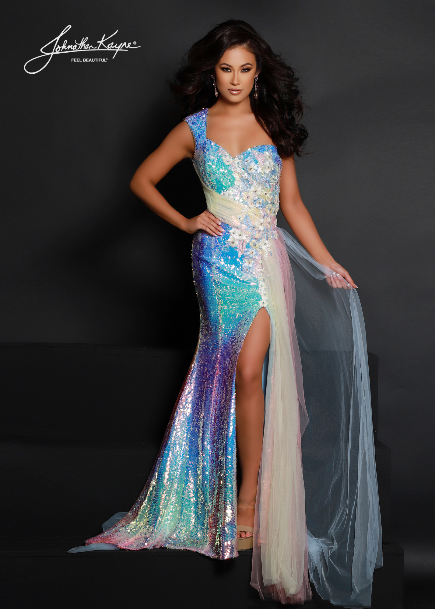 Johnathan Kayne 2650 Long Fitted Sequin One Shoulder Prom Dress Rainbow Overskirt Slit Captivate the crowd in this unique sequin mesh gown with beautiful 3D Floral applique giving way to a ombre side overskirt.  Sizes: 00-16  Colors: Pastel Ombre