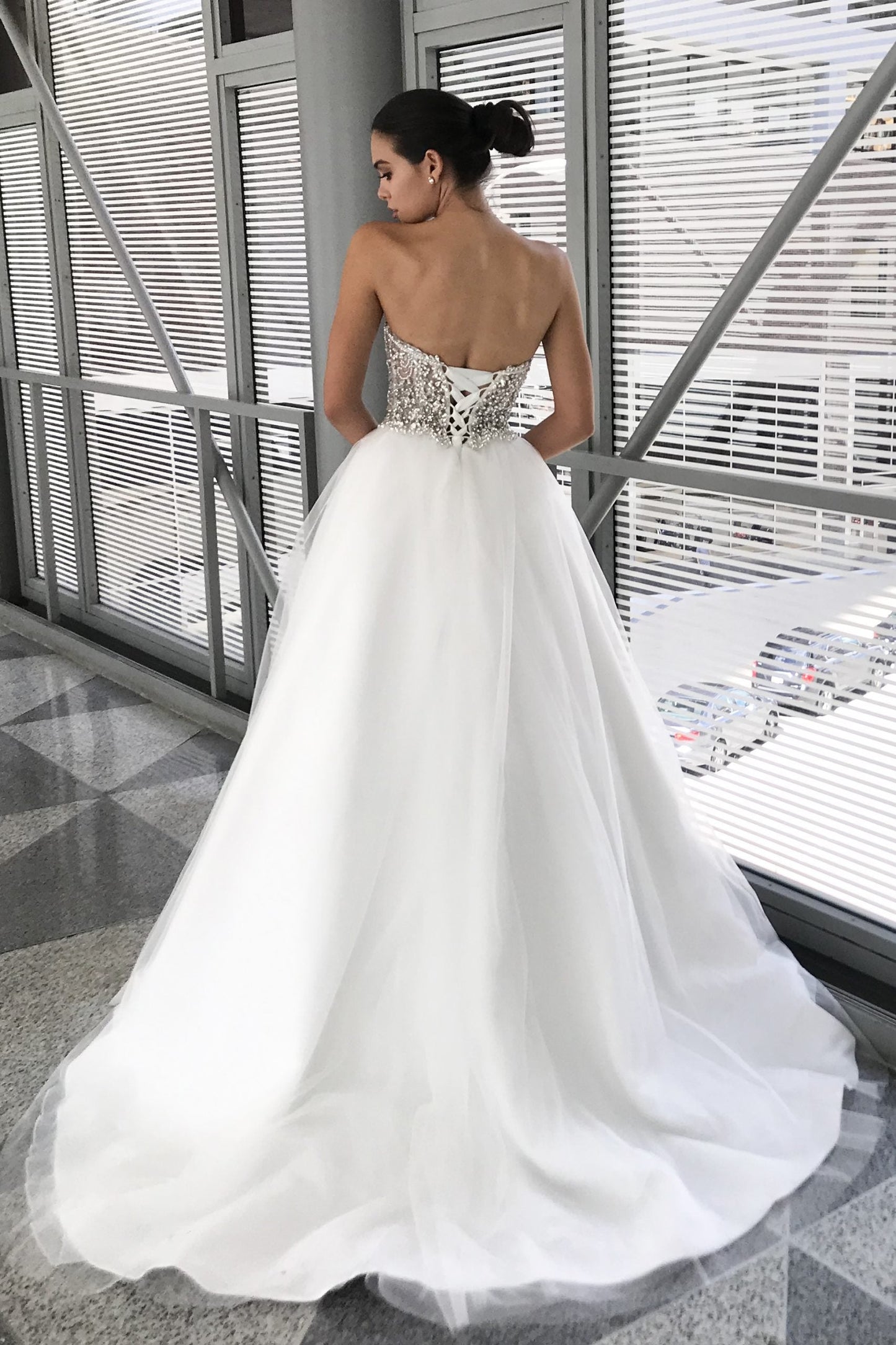 Johnathan Kayne Bridal B200 is a stunning fully crystal embellished Sheer bodice with peak pointes. Lace up corset back closure. A Line Ballgown Wedding Dress & Bridal Gown with a lush Tulle skirt. Jaw Dropping Glam Bridal Style!  Available Sizes: 00,0,2,4,6,8,10,12,14,16  Available Colors: Ivory
