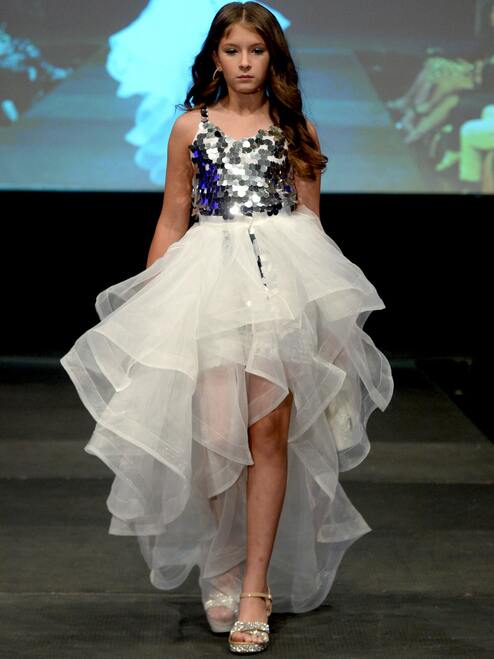 Marc Defang 5002 High Low Sequin Girls Pageant Romper Layered Detachable Overskirt   Fun fashion romper Detachable Overskirt (Price inclusive of the overskirt) Large circle shape beads, Fully beaded romper  Ruffled detachable skirt  Center back invisible zipper Lined top Available Sizes: 4-14  Available Colors: Silver