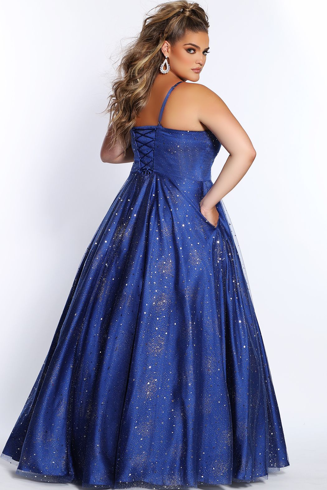 Sydney's Closet SC7326 Fabulous design details of this prom dress features adjustable spaghetti straps into a lace-up back with modesty panel keeps you supported all night. Bold in Blue and Purple, the tulle over satin skirt covered with silver stars, moons, and glitter will sparkle with every twirl. Complete with pockets! 